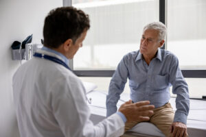 Latin American doctor talking to a patient in a consultaton at his office practice — healthcare and medicine concepts