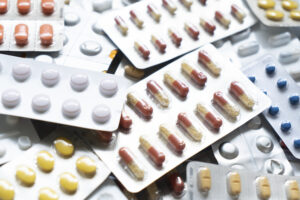 Background of a large group of assorted capsules, pills and blister packs
