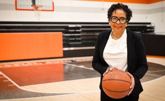 Retired principal Sharron Jackson holds a basketball on the court at her old school.