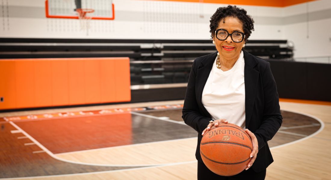 Retired principal Sharron Jackson holds a basketball on the court at her old school.