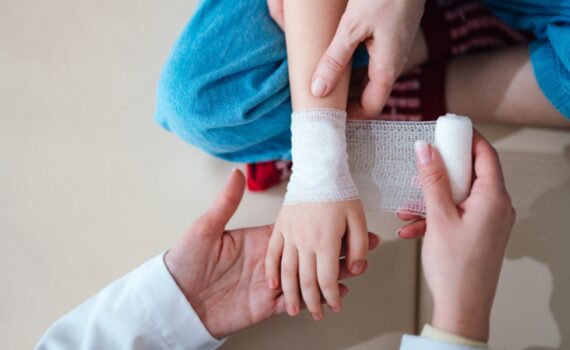 A doctor wraps a child's wound in gauze