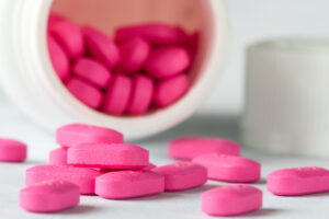 Pink allergy medication spilled from a bottle