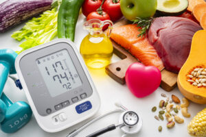 Close up of blood pressure gauge and food products recommended for hypertension control and lower blood pressure. Heart health care